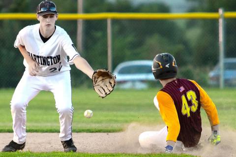 Hartington’s Jaxson Bernecker goes to catch the ball to tag out Neligh’s Hunter Charf during the Class C District Tournament action Monday night in Pierce.